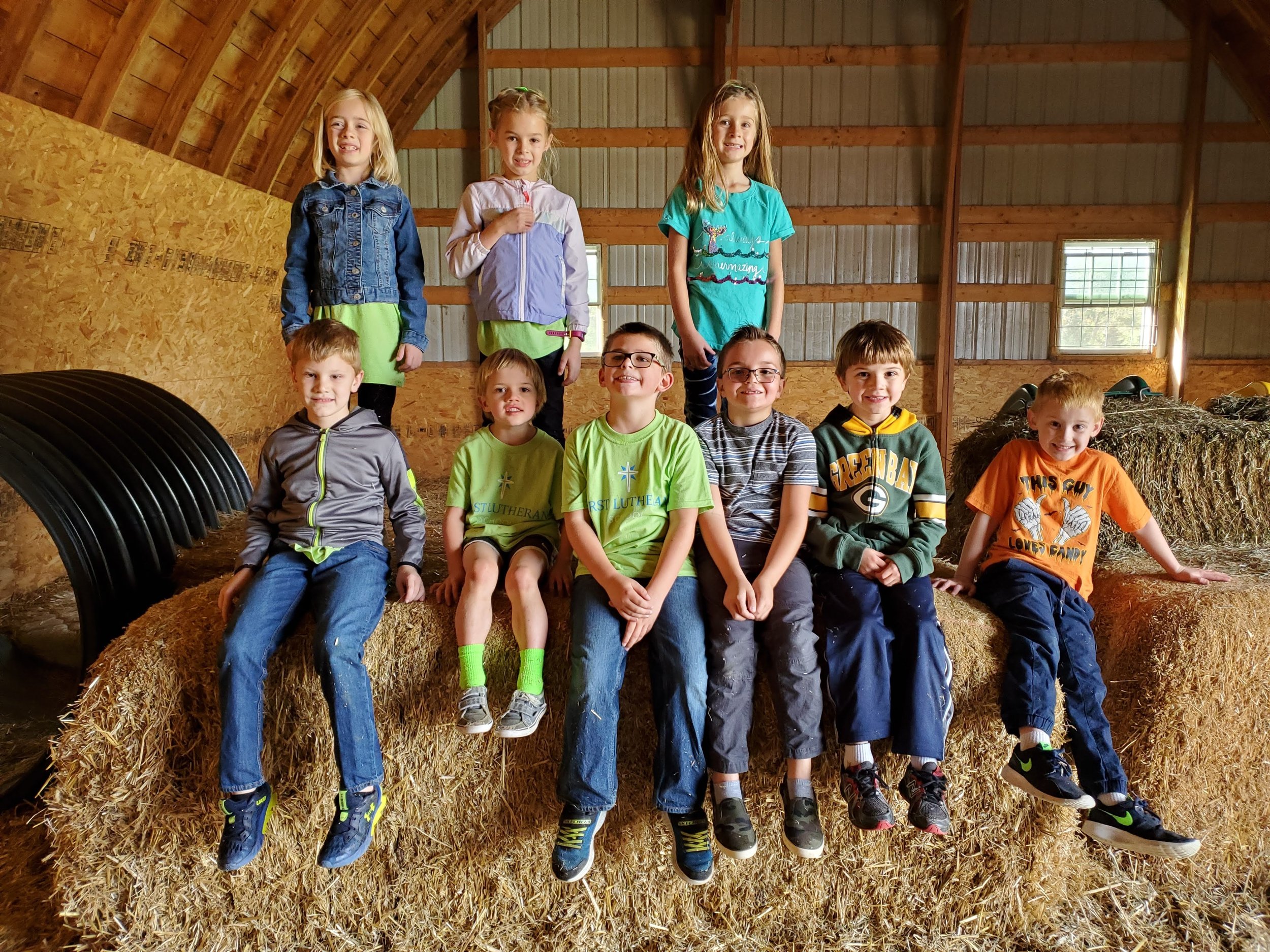 Students sitting on hay bales during a class field trip