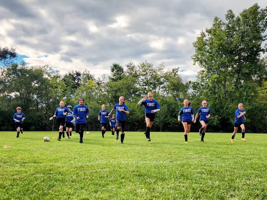 First Lutheran soccer players running drills on the field